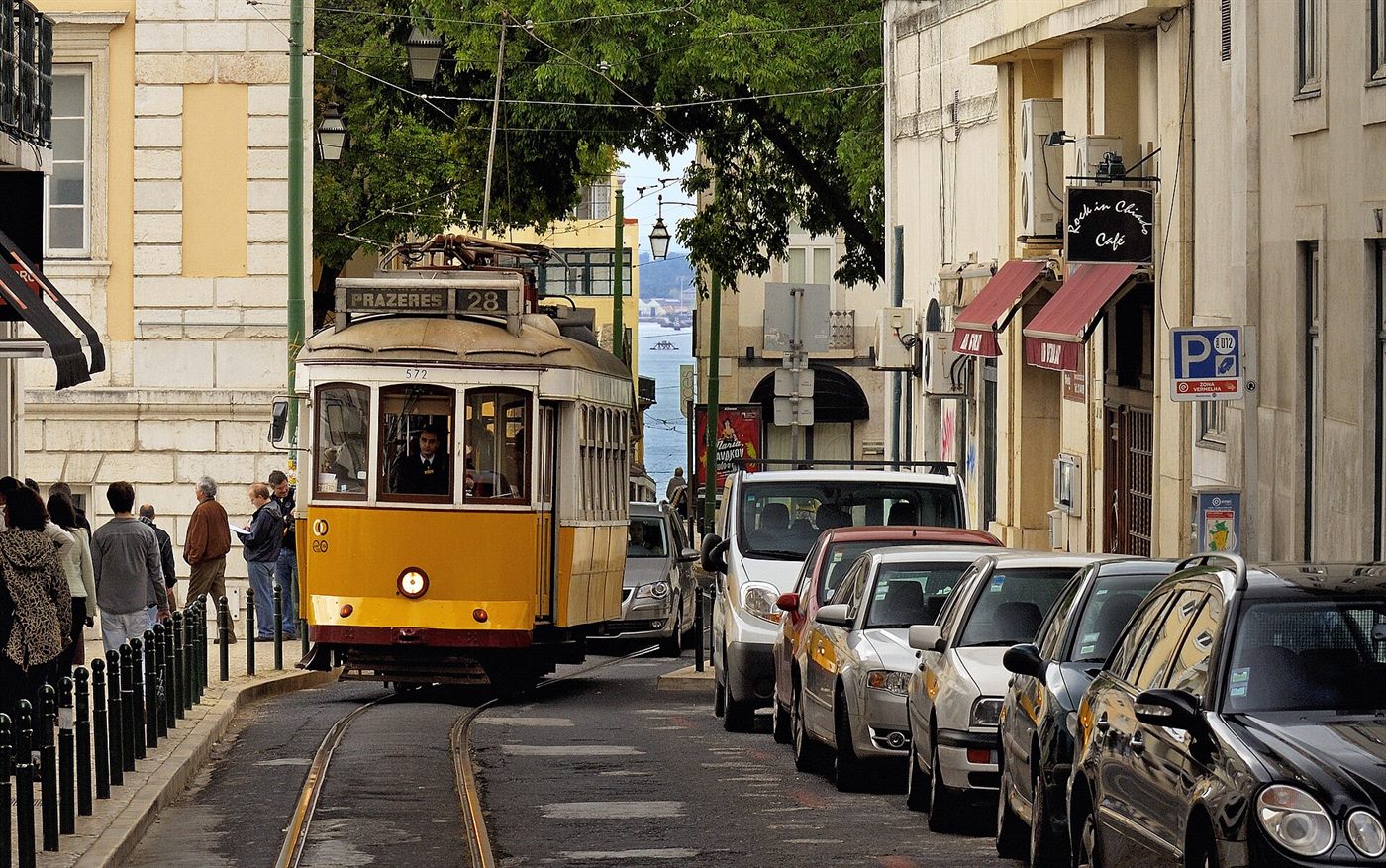 Lisbon street with tiled facades and a yellow tram